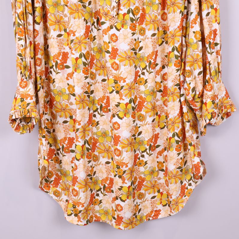 Närbild på ärmslut och nederdel med böjd fåll