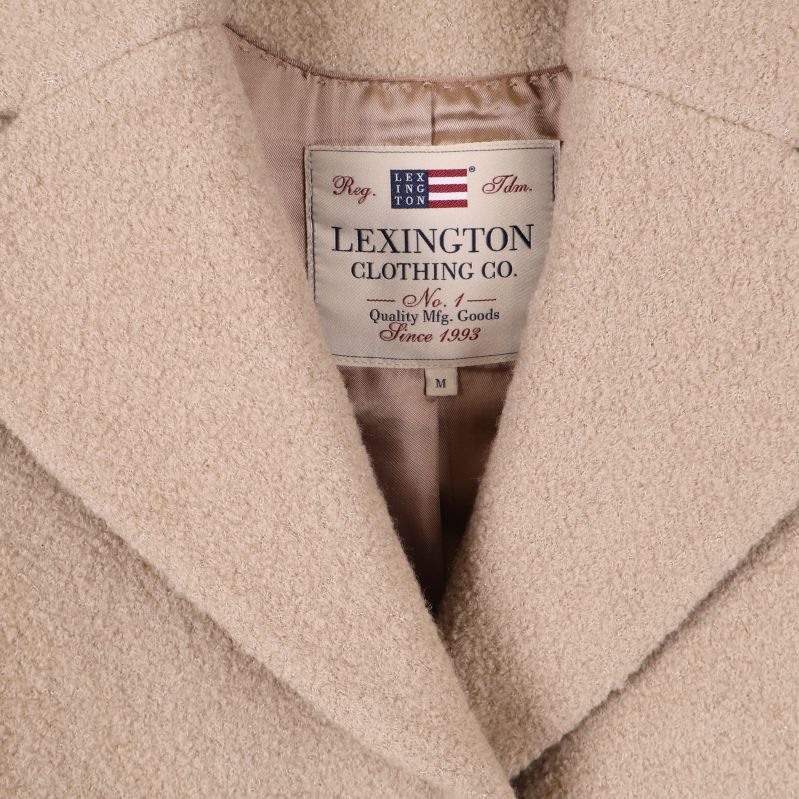 Närbild av etiketten Lexington Clothing Co vid kappans krage