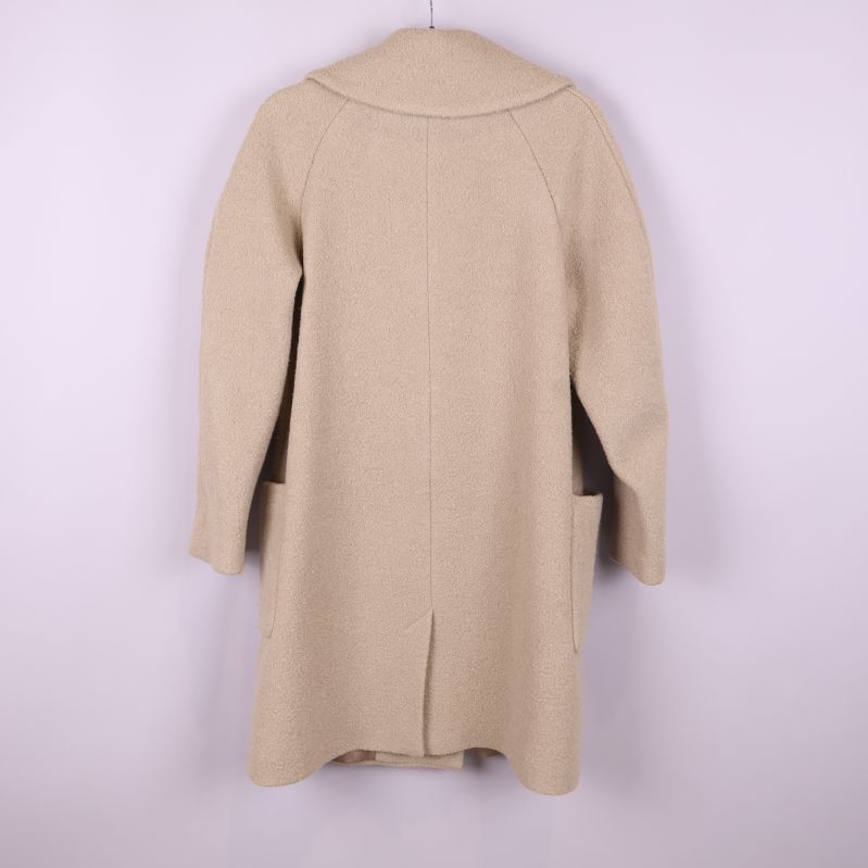 Baksida av beige kappa visar längd och ryggdetalj