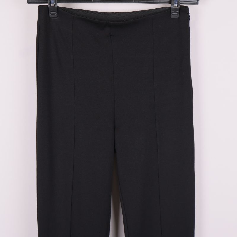 Detaljbild av midjan och framsidan på svarta byxor