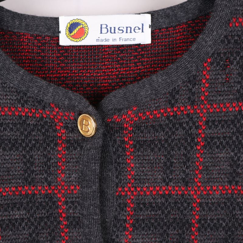 Närbild på Busnel-logotyp och guldknapp vid halsen