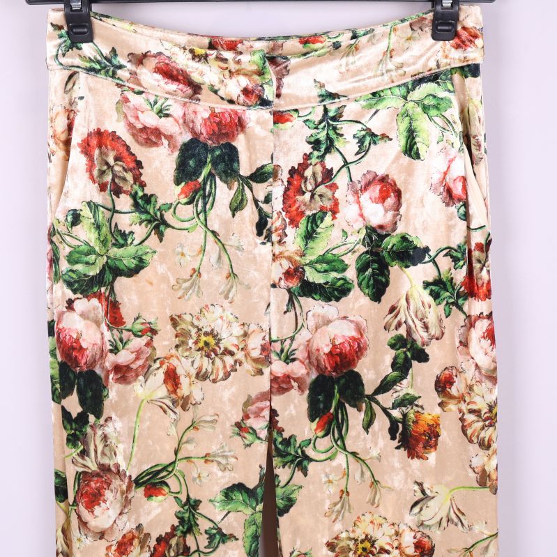 Överkant på byxorna med blommönster och knäppning synlig