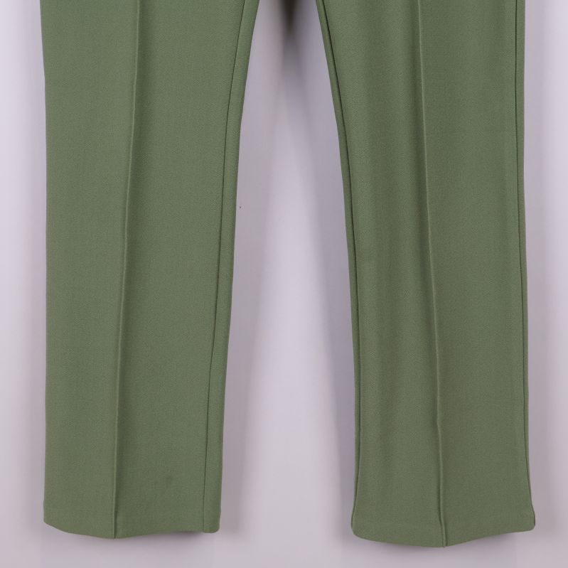 Nedre delen av gröna byxben med synligt pressveck