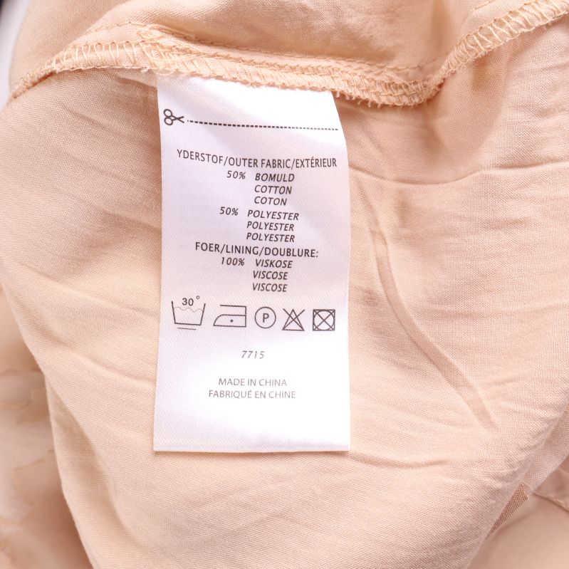 Materialetikett som visar andel bomull och polyester samt viskosfoder