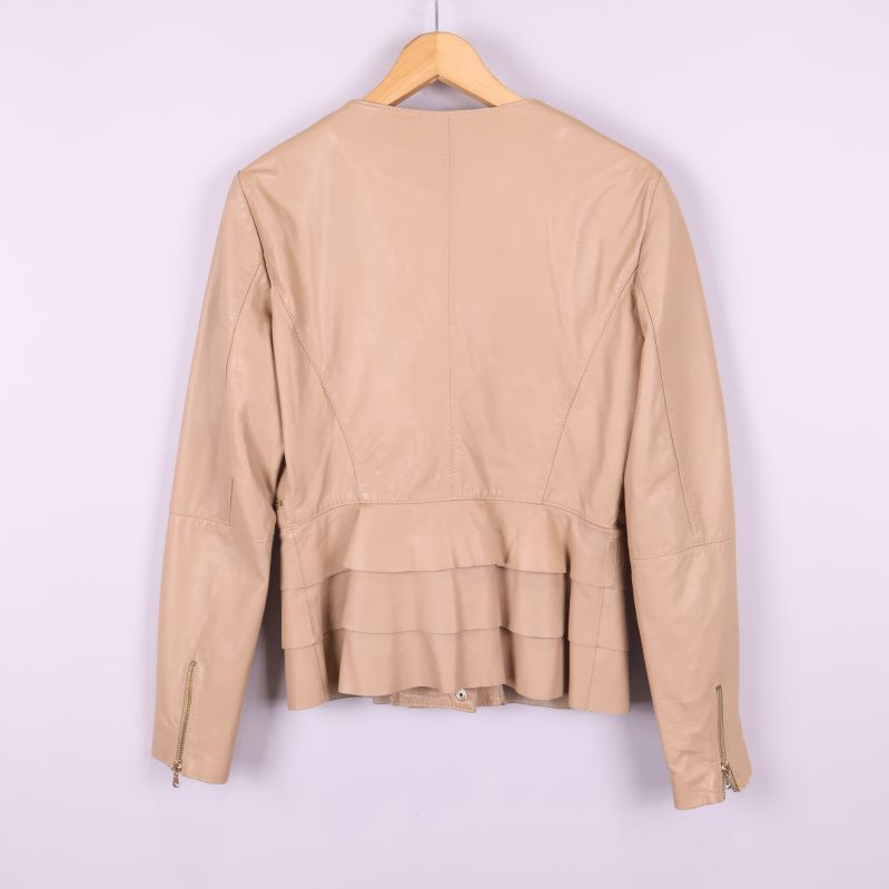 Baksida av beige skinnjacka med volangdetalj