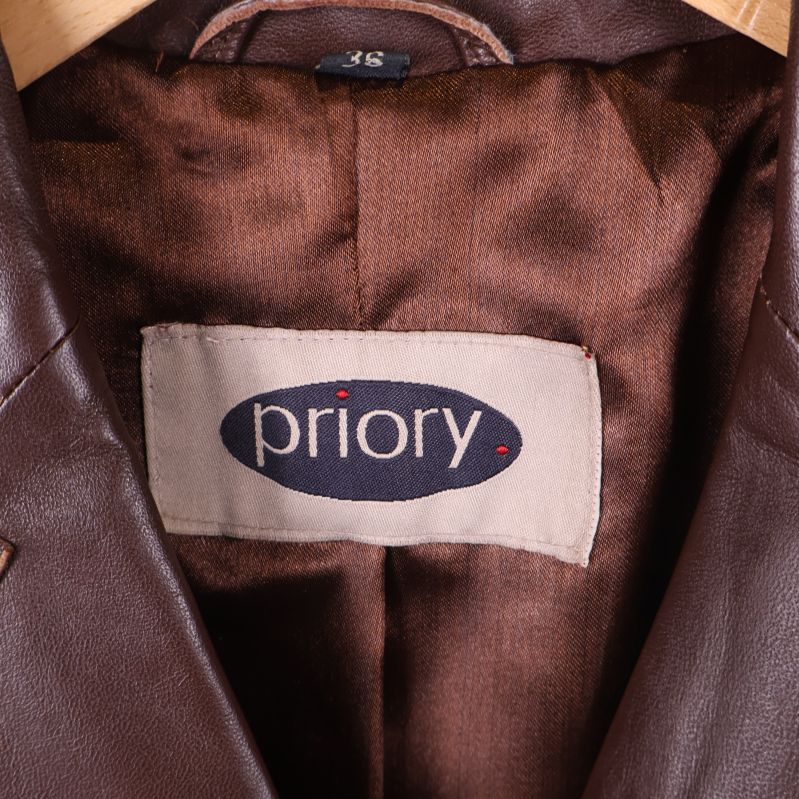 Närbild på Priory-märkesetikett i brun jacka