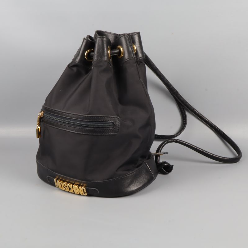 Svart Moschino-ryggsäck i sidovy med gulddetaljer