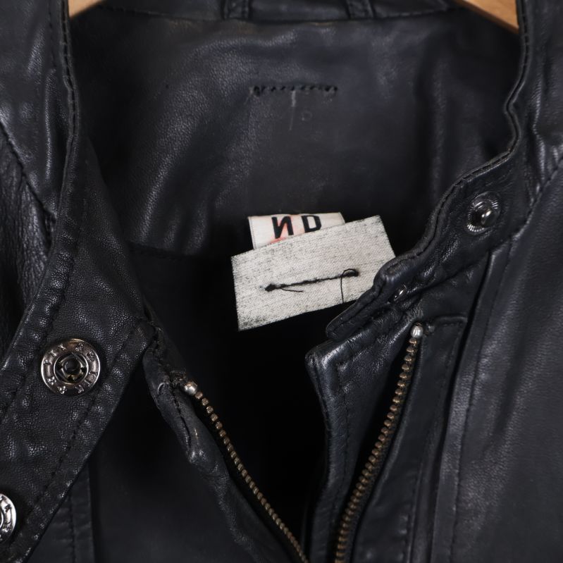 Detaljbild på etikett och sömmar inuti skinnjackan