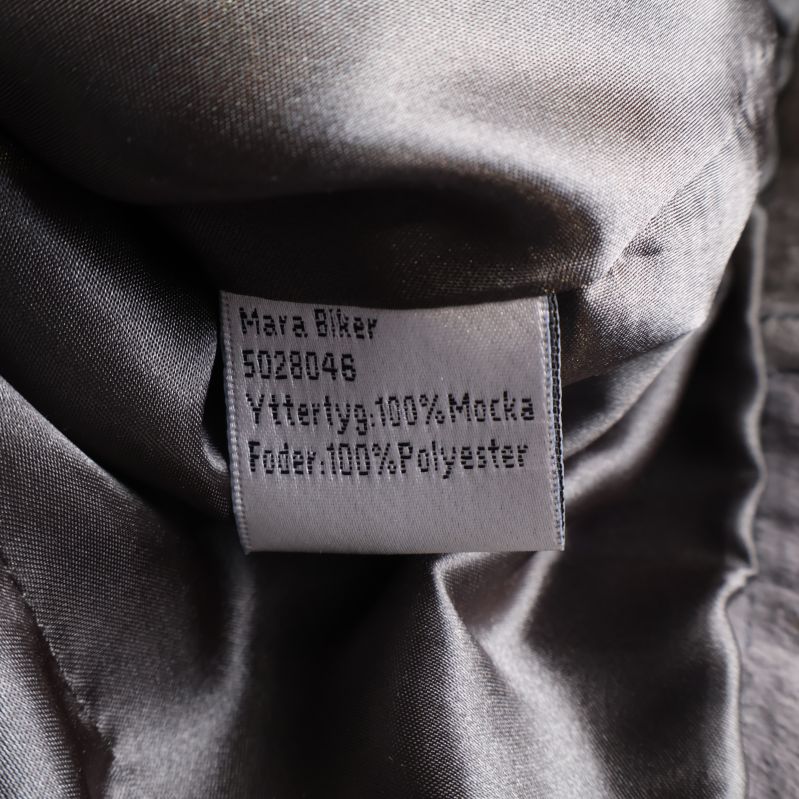 Materiallapp med text Yttertyg 100% Mocka Foder 100% Polyester