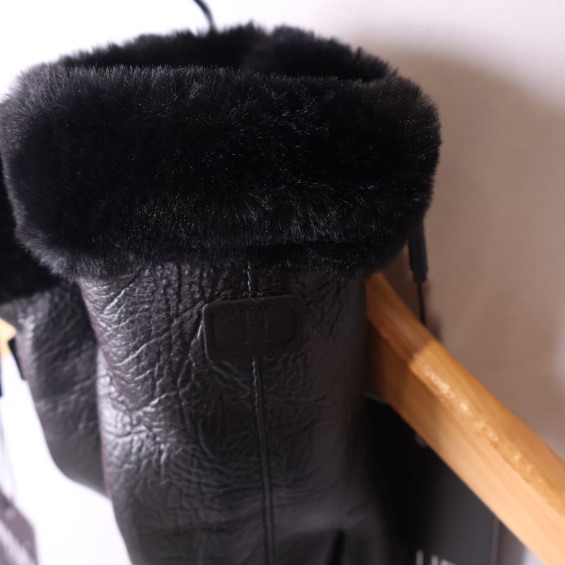 Närbild på handskens uppvikta kant med svart fuskpäls