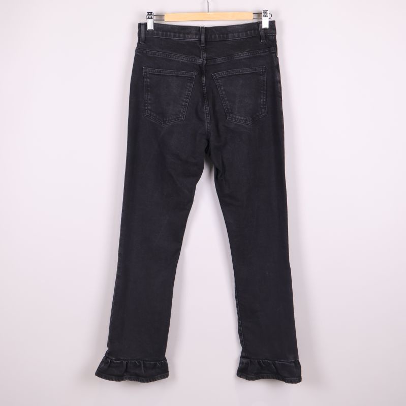 Svarta jeans med volangkant upphängda bakifrån