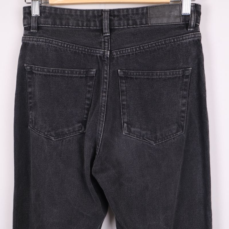 Närbild på bakfickor och midja av svarta jeans