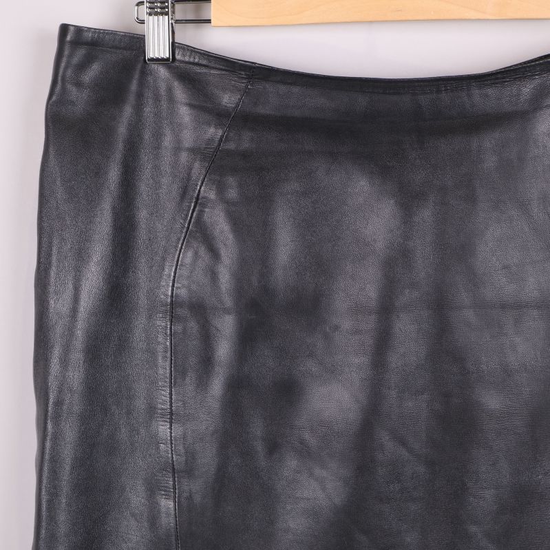 Närbild på sömdetalj upptill på svart skinnkjol