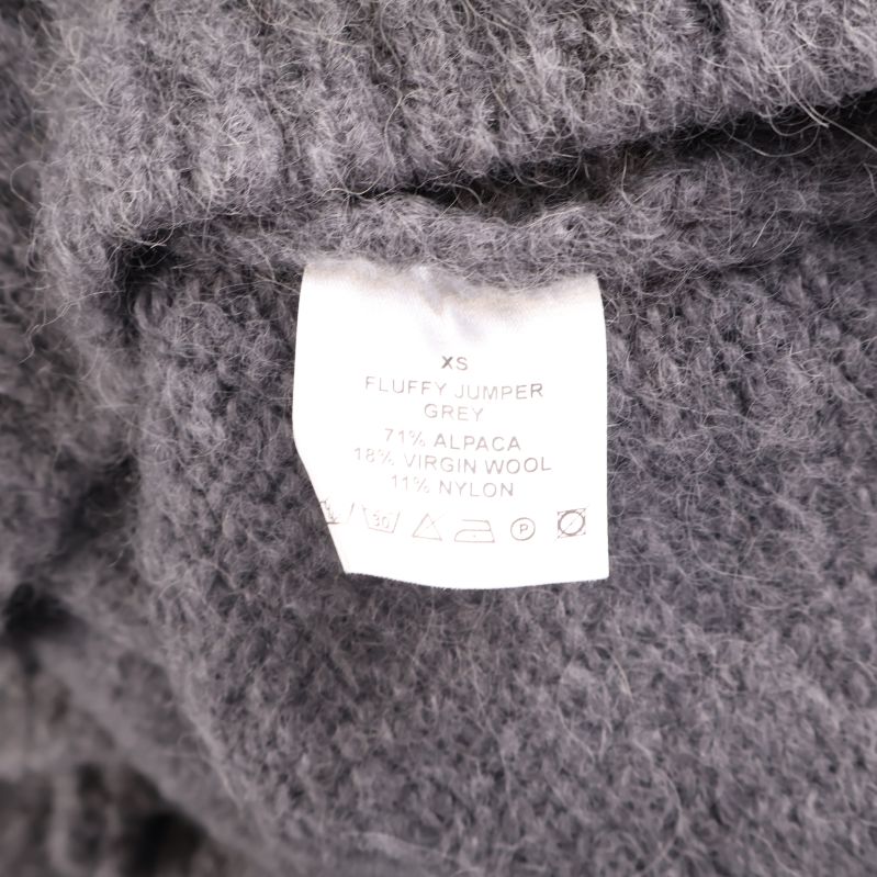 Materialetikett med information om alpackaull, ny ull och nylon