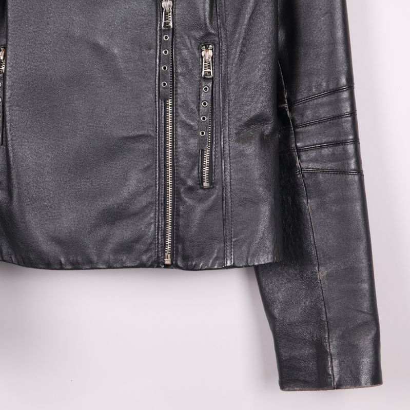 Närbild på nedre delen av jackan visar två dragkedjor