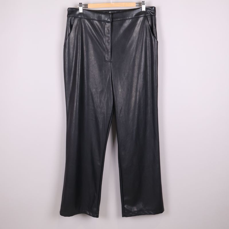 Framifrån av svarta vida byxor i konstläder