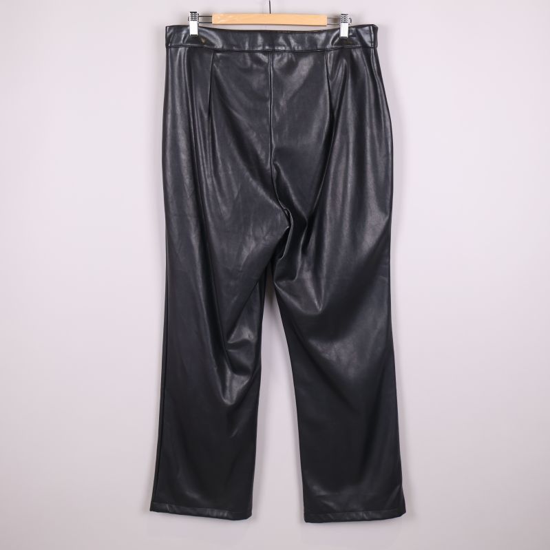 Baksidan av svarta vida byxor i konstläder