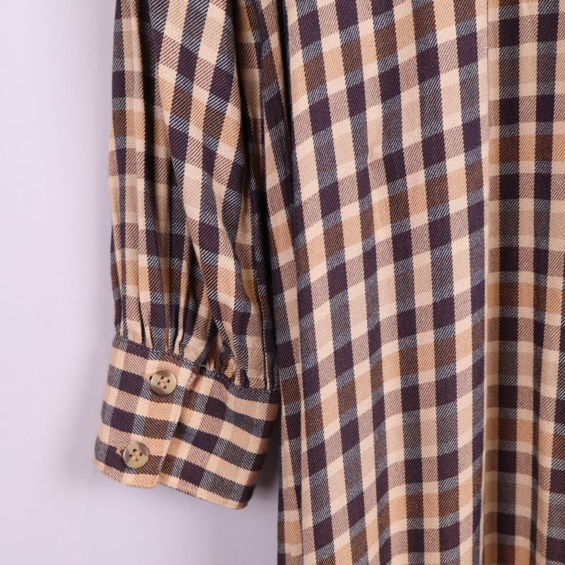 Ärm med manschett och två knappar på rutigt tyg