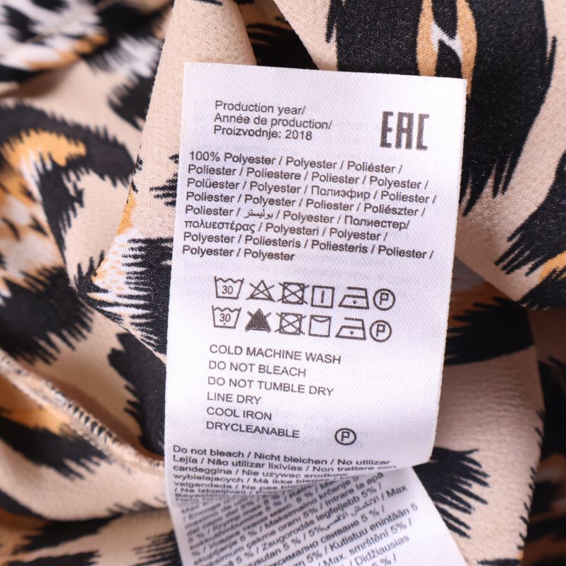 Materiallapp visar 100% polyester på leopardmönstrad skjorta