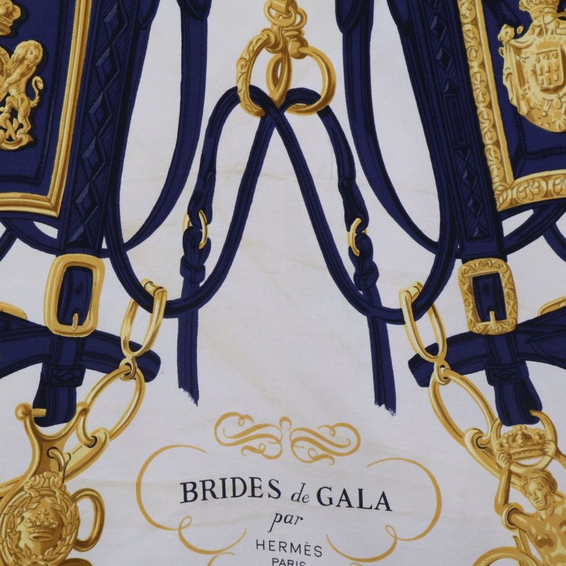 Hästmotiv och gulddetaljer i närbild på scarf