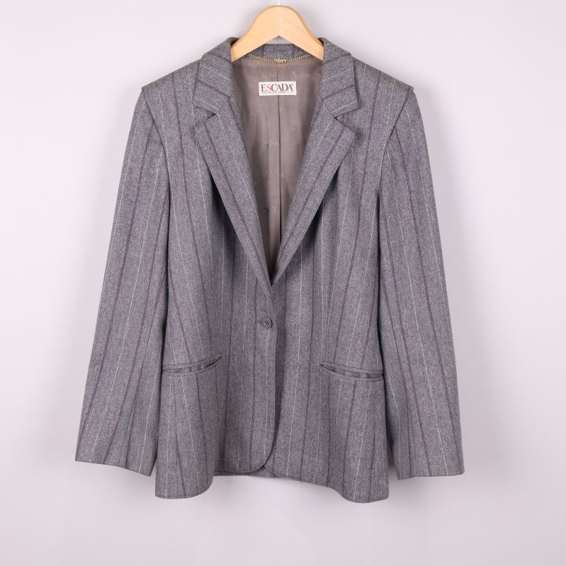 Grå kavaj med kritstrecksrandigt mönster hängande på galge