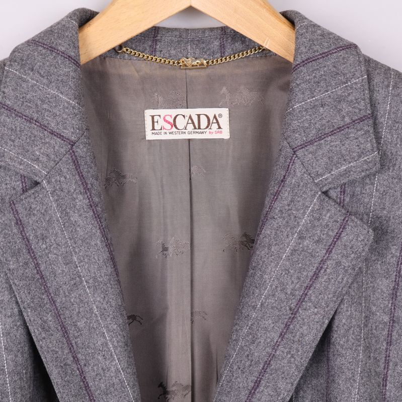 Närbild på Escada-logotypen i kavajens krage