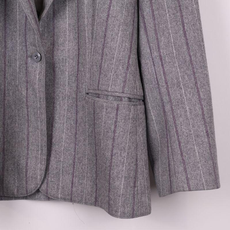 Detalj på höger ficka och nederdel av kritstrecksrandig kavaj