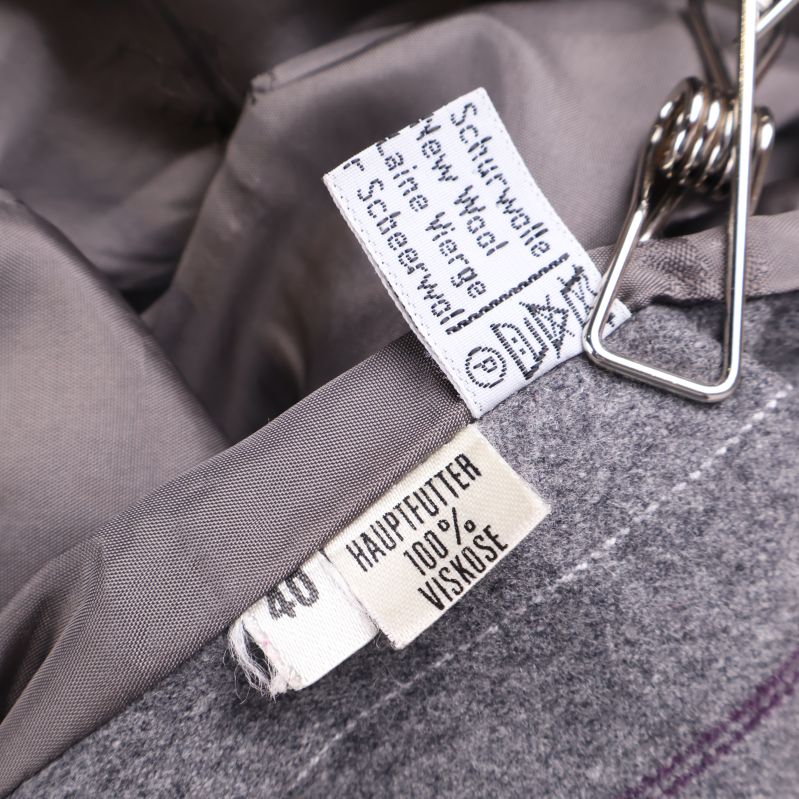 Närbild på tvättråd och materialetikett insydd i kavajen