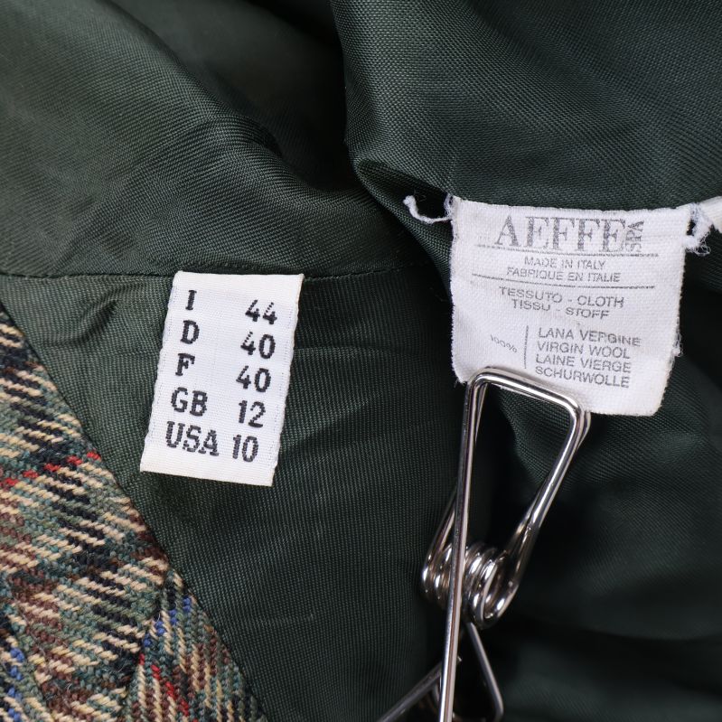 Två storleksetiketter och materialinfo i kavajens insida