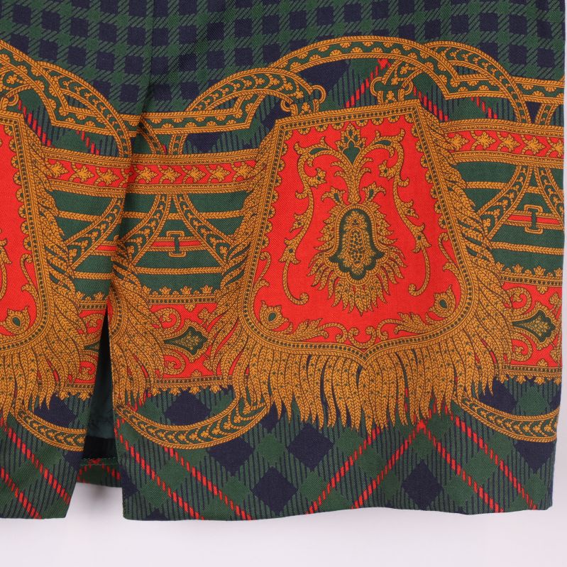 Närbild på kjolens nedre del med starkt mönster i rött och guld