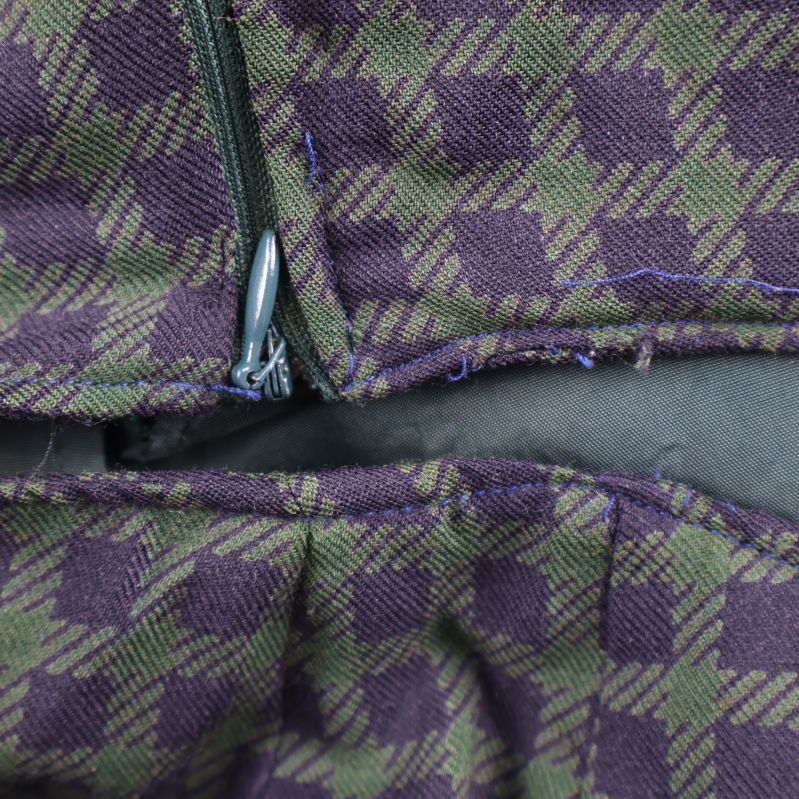 Närbild på kjolens blixtlås och rutmönstrat tyg