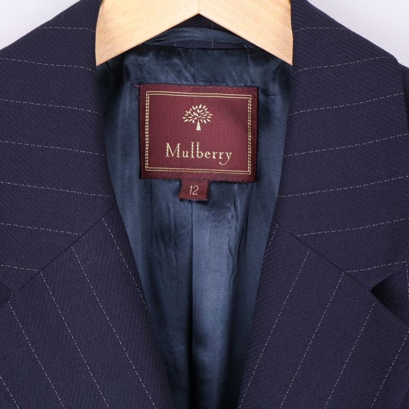 Närbild på Mulberry-märke och storlekstagg i kavajens krage