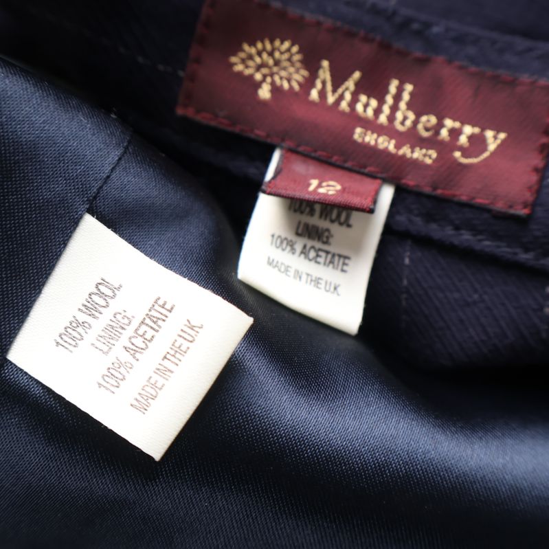 Materialetikett visar 100% ull och 100% acetatfoder i kavaj