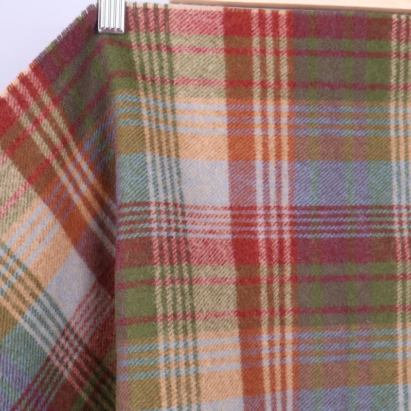 Närbild på mjuk rutig yta i grönt, rött och beige