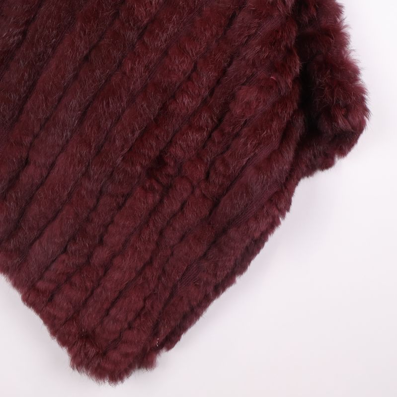Närbild nertill på vinröd poncho med textur