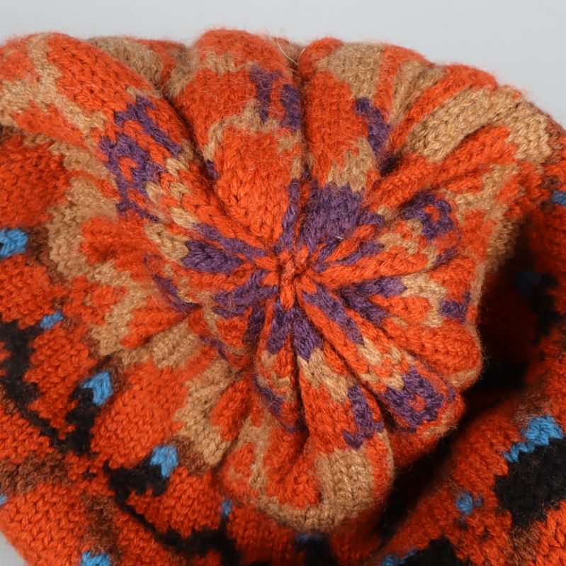 Topp av mössa med mönstrad stickning i orange