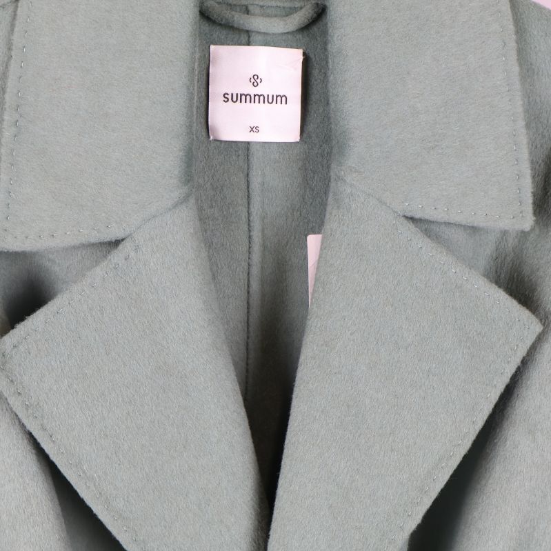 Närbild av krage och etikett på ljusgrön kappa