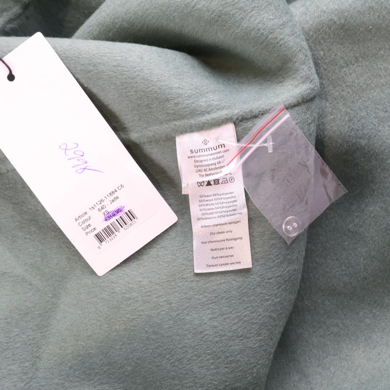 Materiallapp och extraknapp på insidan av kappan