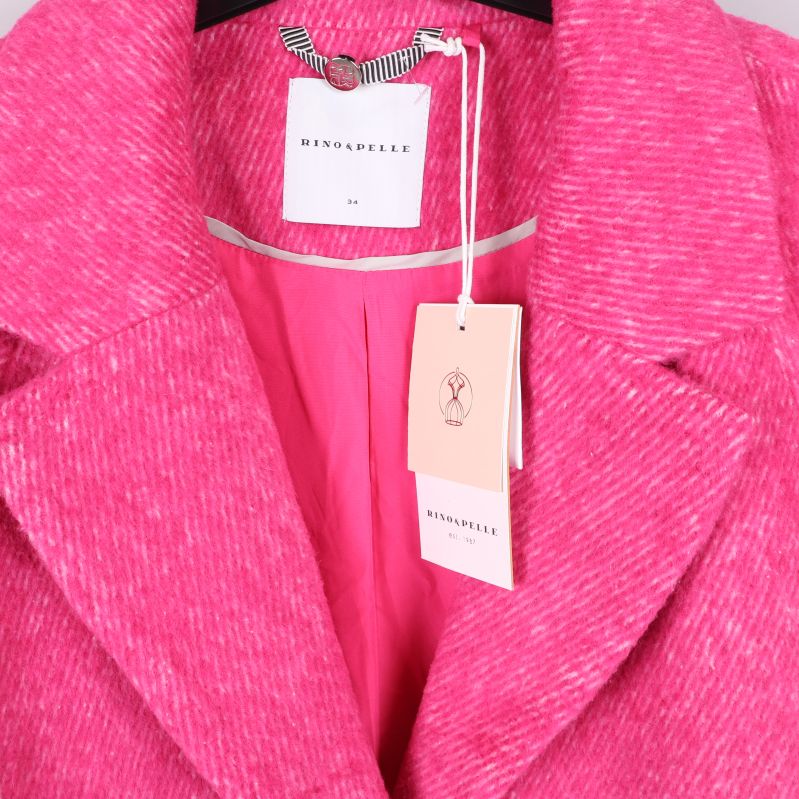Närbild på krage, etiketter och innerfoder på rosa kappa