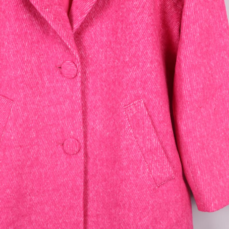 Knappar och fickor med tydlig struktur i rosa tyg