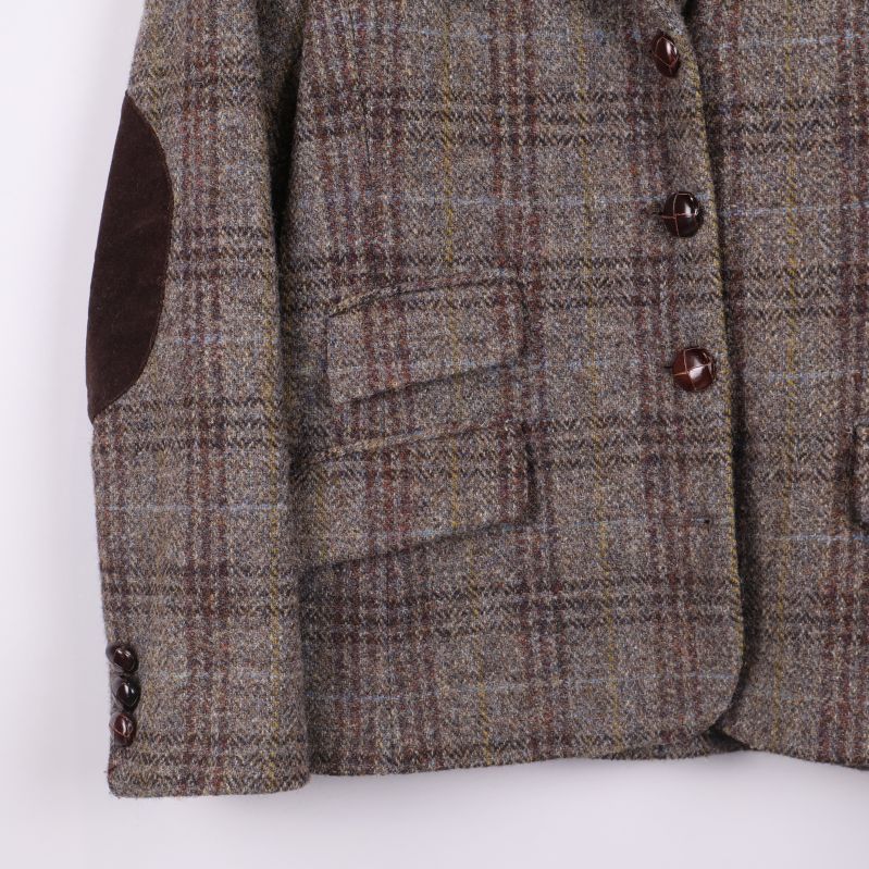 Närbild på kavajens ärm, mockadetalj och knappar