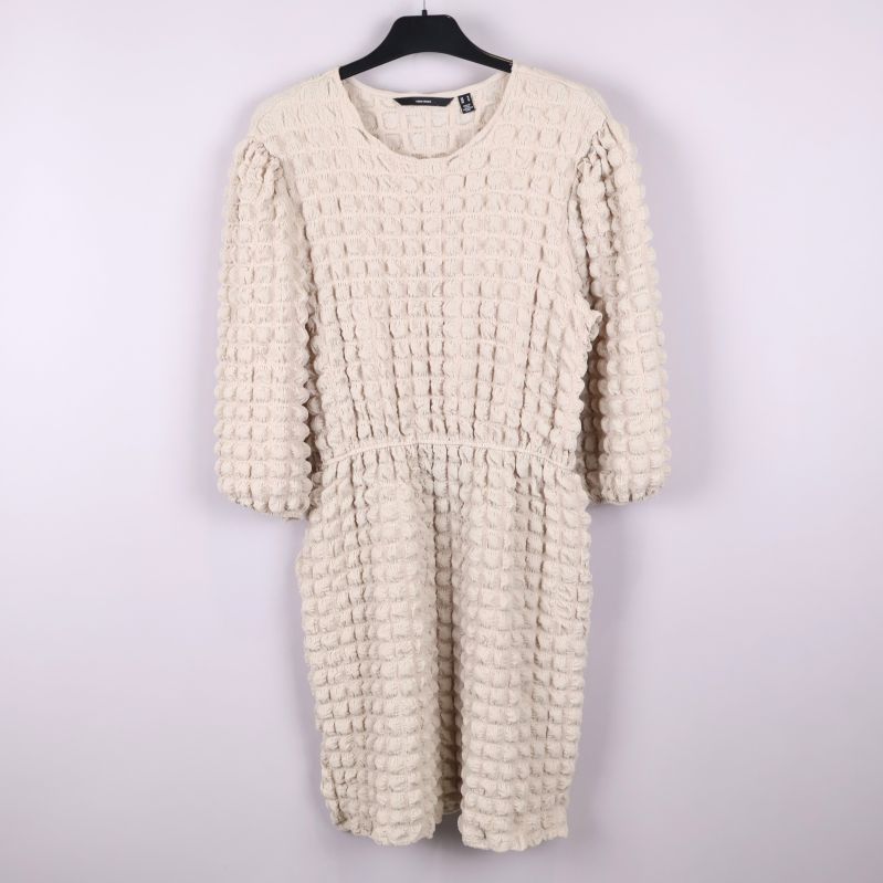 Krämfärgad strukturerad klänning upphängd framifrån