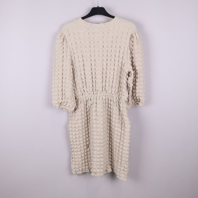 Klänningens baksida visar struktur och ärmlängd