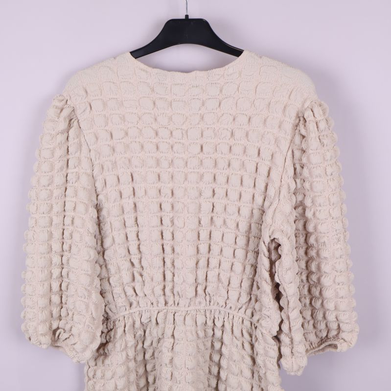 Baksida av klänningen nära visar tygstruktur