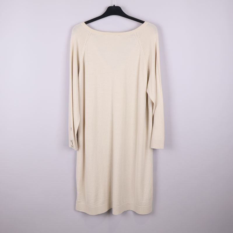 Baksida av beige stickad klänning