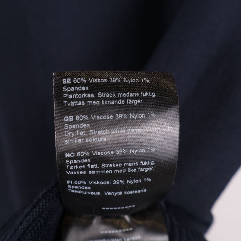 Materialetikett visar 60% viskos, 39% nylon, 1% spandex