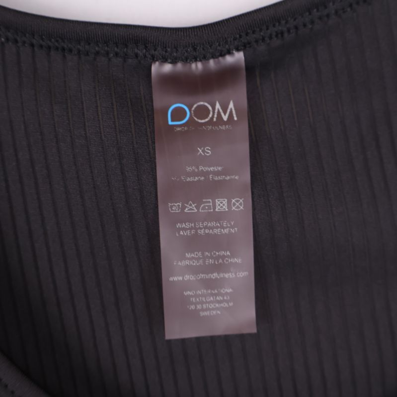 Närbild materiallapp DOM XS 90% polyester 10% elastan
