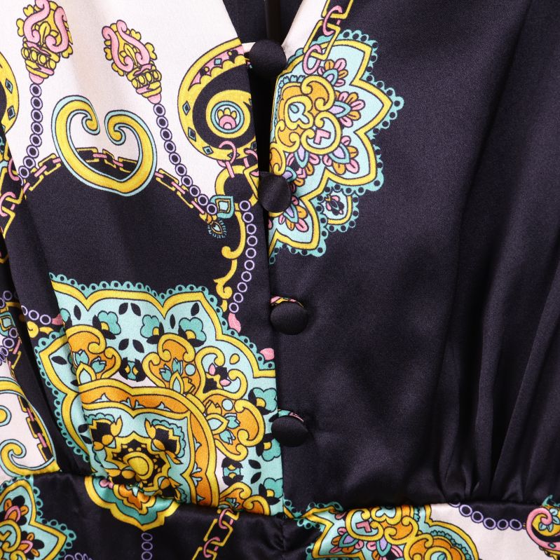 Närbild på tygklädda knappar och paisleymönster i ljust och svart