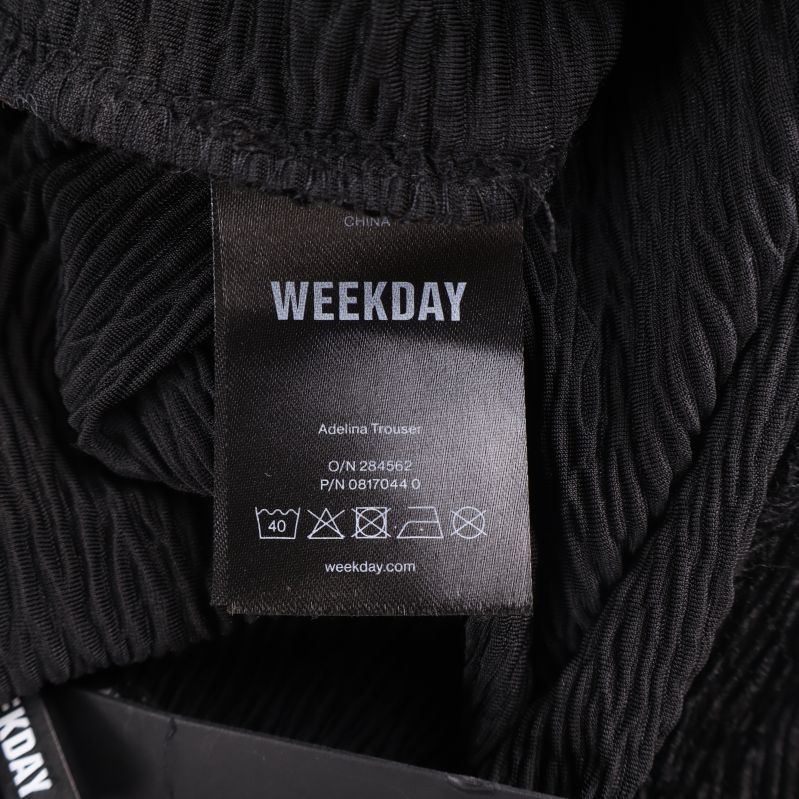 Materiallapp med skötselanvisningar och Weekday logotyp
