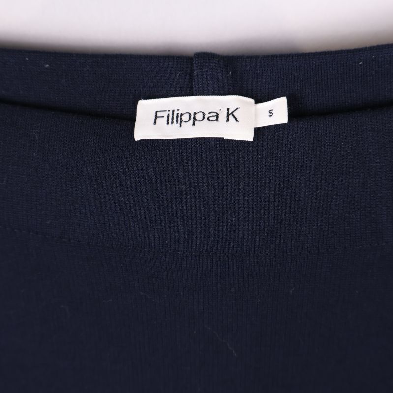 Närbild på Filippa K-logotyp och storleksetikett insydd i kjolen